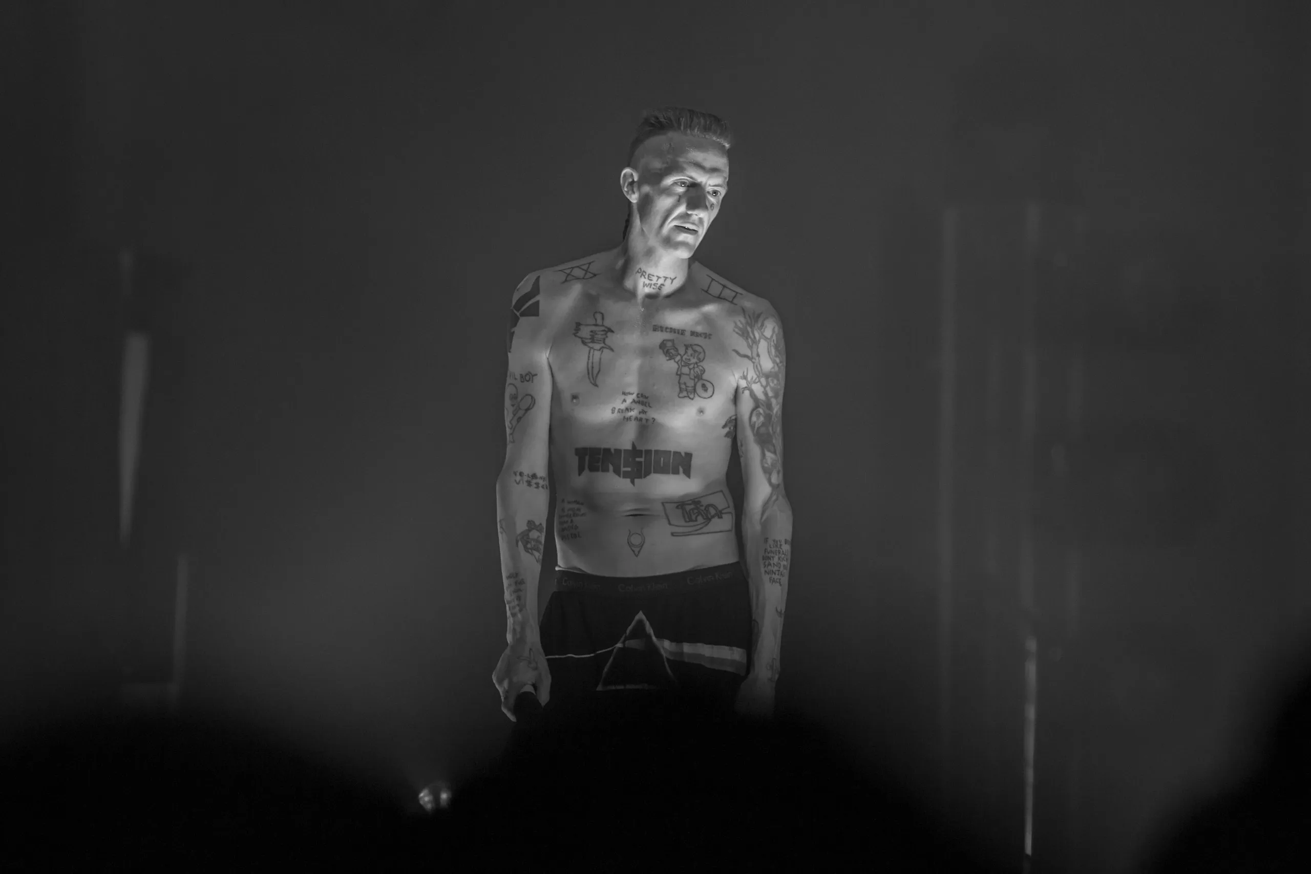 Артист Die Antwoord на тёмной сцене в чёрно-белом кадре